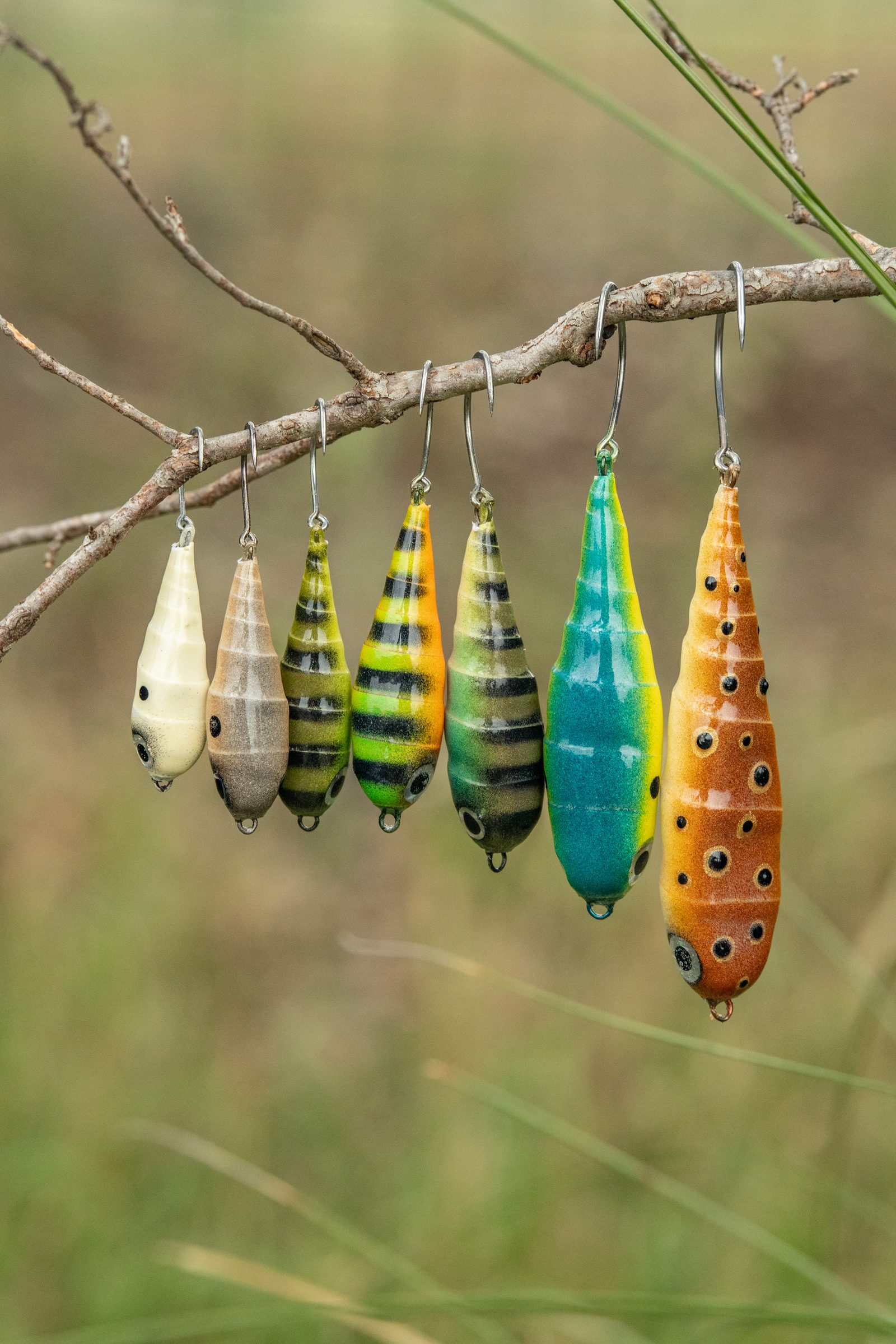 A run of airbrushed Spiral Spook flies hanging on a branch